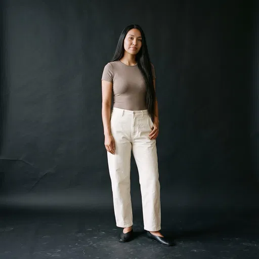 Woman In Minimalist Basics On Black Backdrop
