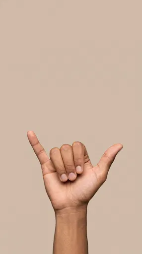 Hand Making Shaka Sign on Beige