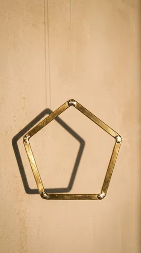 Suspended Brass Pentagon With Shadow