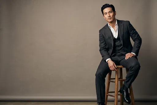 Man in Charcoal Suit on Studio Stool