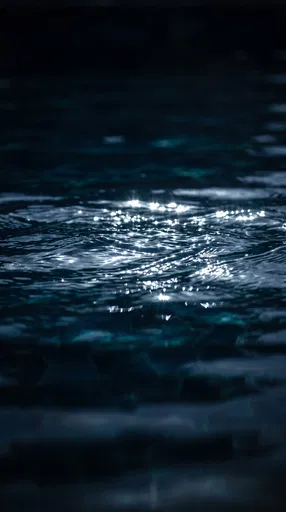 Dark Rippling Water With Silver Reflections