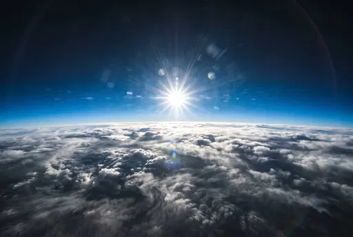 Stratospheric View Above Clouds With Sun Flare