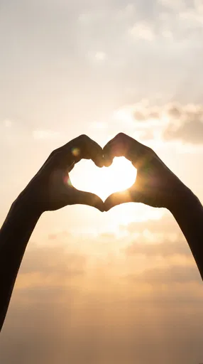 Silhouette Hands Forming Heart Against Sunset