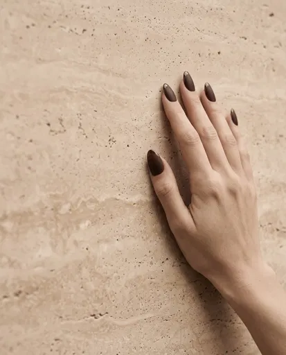 Hand With Brown Matte Nails On Travertine
