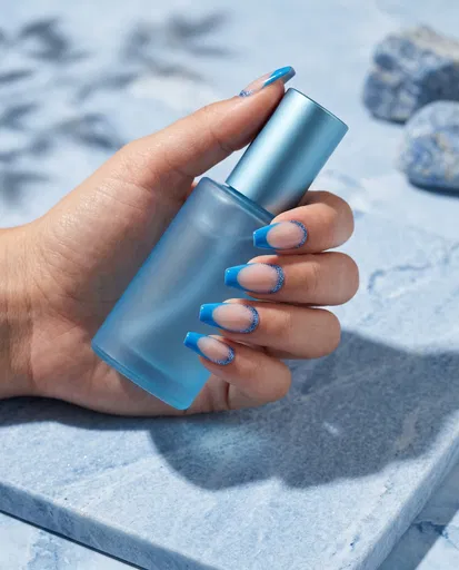 Blue French Tip Manicure Holding Bottle
