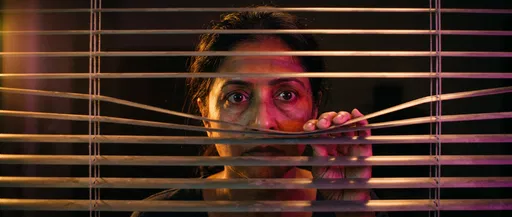 Woman Peeking Through Window Blinds