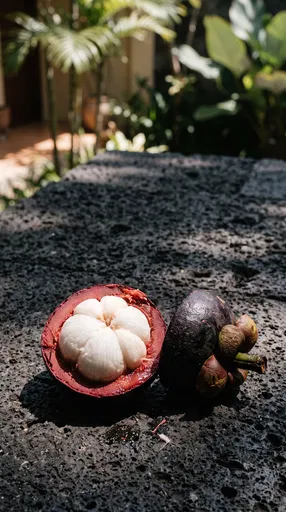 Halved Mangosteen on Volcanic Stone