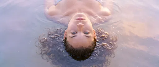 Woman Floating Serenely in Pastel Water