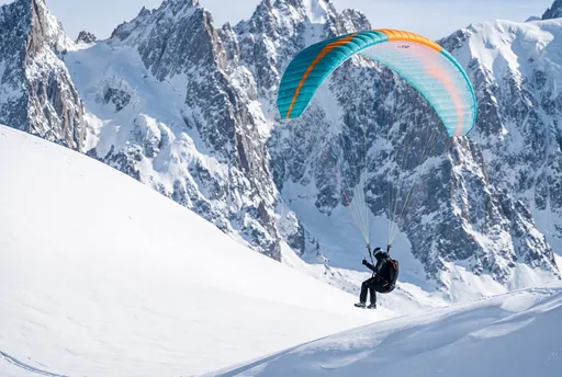 Paraglider Soaring Over Snowy Alpine Peaks