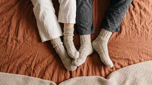 Couple Feet in Knitted Socks on Bed