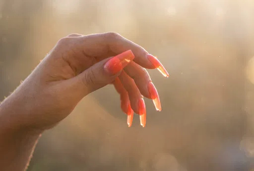 Backlit Hand With Translucent Coral Nails