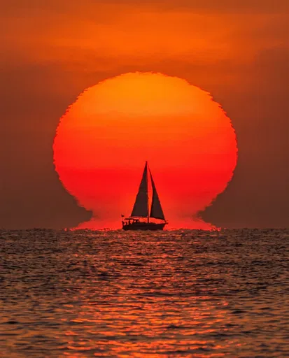 Sailboat Silhouetted Against Giant Red Sunset