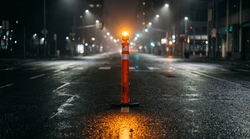 Illuminated Traffic Pylon on Wet Night Street