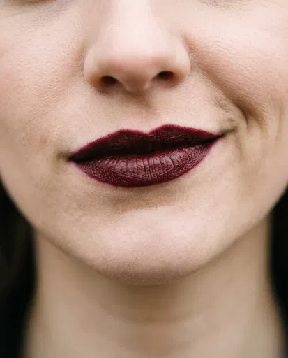 Close-Up of Woman Smirking in Dark Lipstick