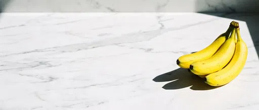 Yellow Bananas on White Marble Countertop