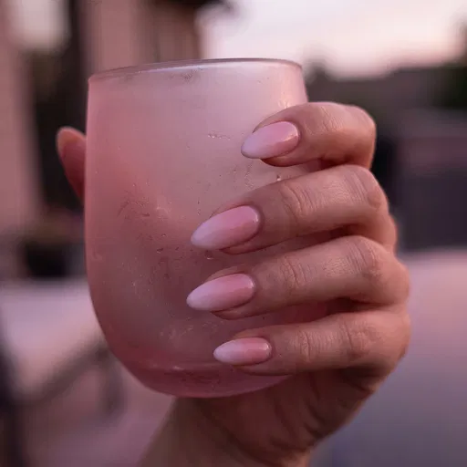 Hand with Pink Ombre Nails Holding Glass