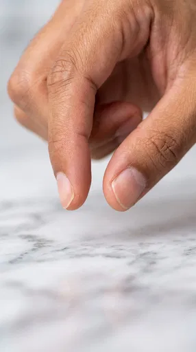 Macro Hand Pinching Above Marble Surface