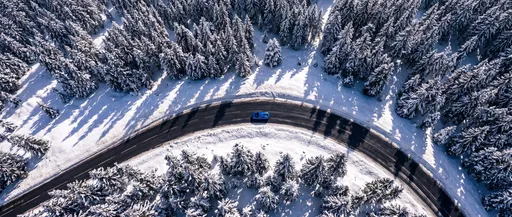 Aerial View of Supercar on Snowy Road
