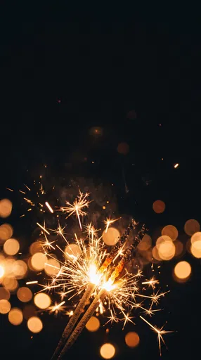 Golden Sparklers Burning Against Dark Bokeh Background