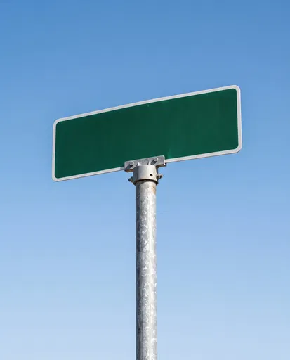 Blank Green Street Sign Against Blue Sky