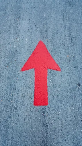 Red Painted Arrow on Gray Asphalt