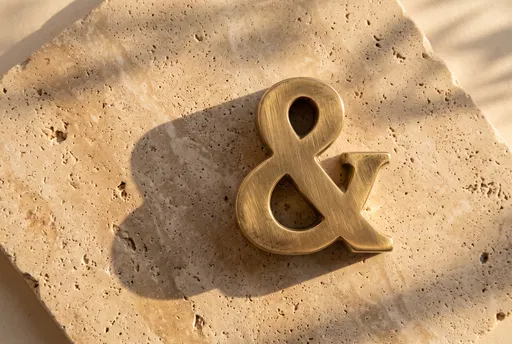 Brushed Brass Ampersand on Travertine Stone
