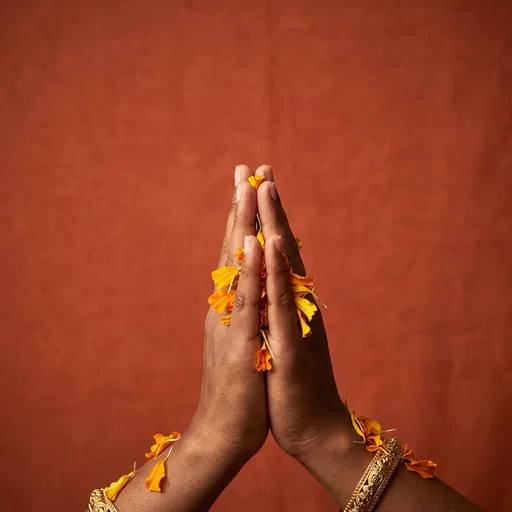Hands in Prayer With Marigold Petals