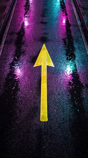 Yellow Arrow on Wet Neon Asphalt