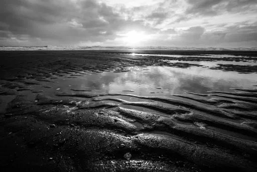 Monochrome Sunset Over Wet Beach Ripples
