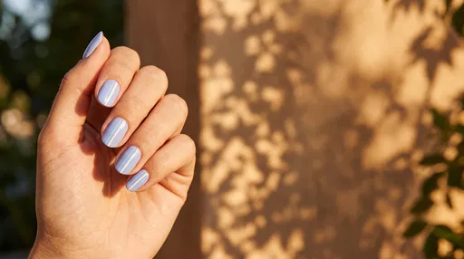 Hand With Pastel Blue Striped Manicure