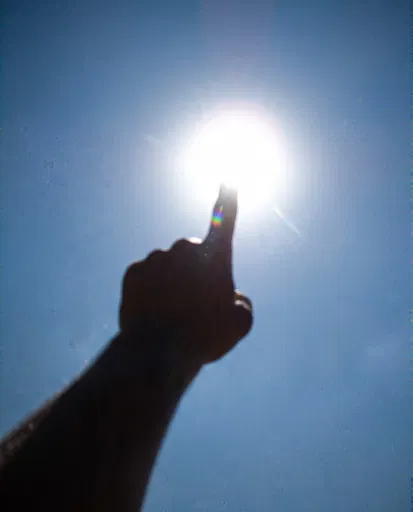 Silhouetted Finger Pointing at the Sun