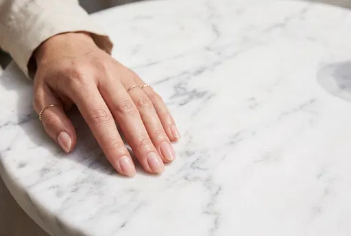 Hand With Nude Nails on Marble