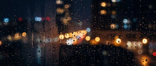 Raindrops on Night Window with City Bokeh