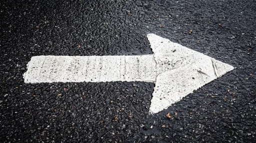 White Right Arrow on Wet Asphalt