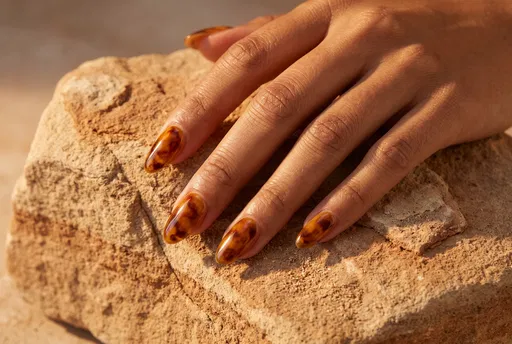 Hand with Tortoiseshell Nails on Sandstone
