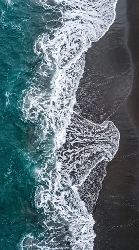 Aerial View of Turquoise Surf and Dark Sand