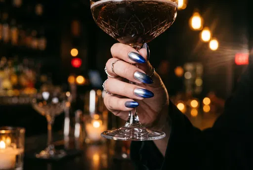 Hand With Blue Ombre Nails Holding Glass