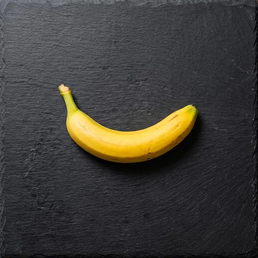 Single Yellow Banana on Black Slate