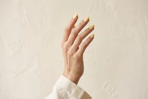 Hand With Glossy Butter Yellow Manicure