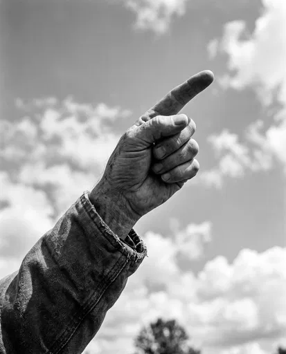 Weathered Hand Pointing Toward Cloudy Sky
