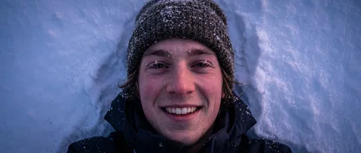 Smiling Man Lying in Fresh Snow