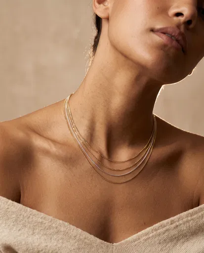 Layered Gold and Silver Necklaces on Olive Skin