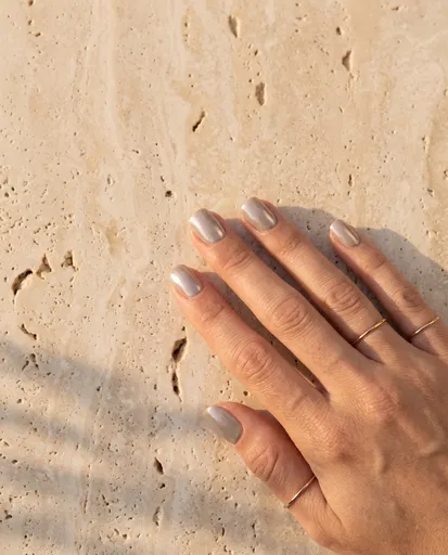 Hand With Pearl Chrome Nails on Stone