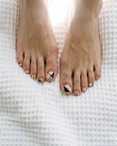 Feet With Geometric Nail Art on Towel