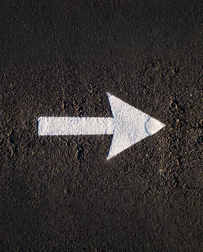 White Right Arrow on Dark Asphalt