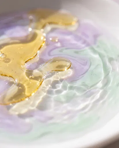 Macro Golden Oil on Pastel Cream