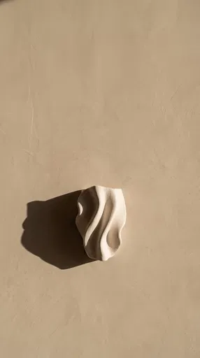 Sculptural Plaster Sconce on Beige Wall