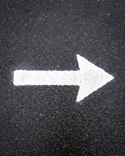 White Arrow Painted on Wet Asphalt