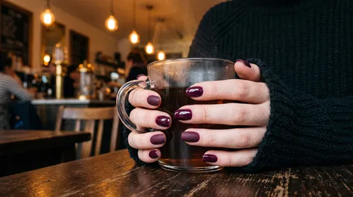 Hands With Plum Manicure Holding Glass Mug