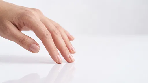 Manicured Hand on Reflective White Surface